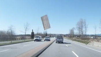 Plywood Board Flies Out The Back Of A Pickup Truck And Lands On Truck In Opposite Lane